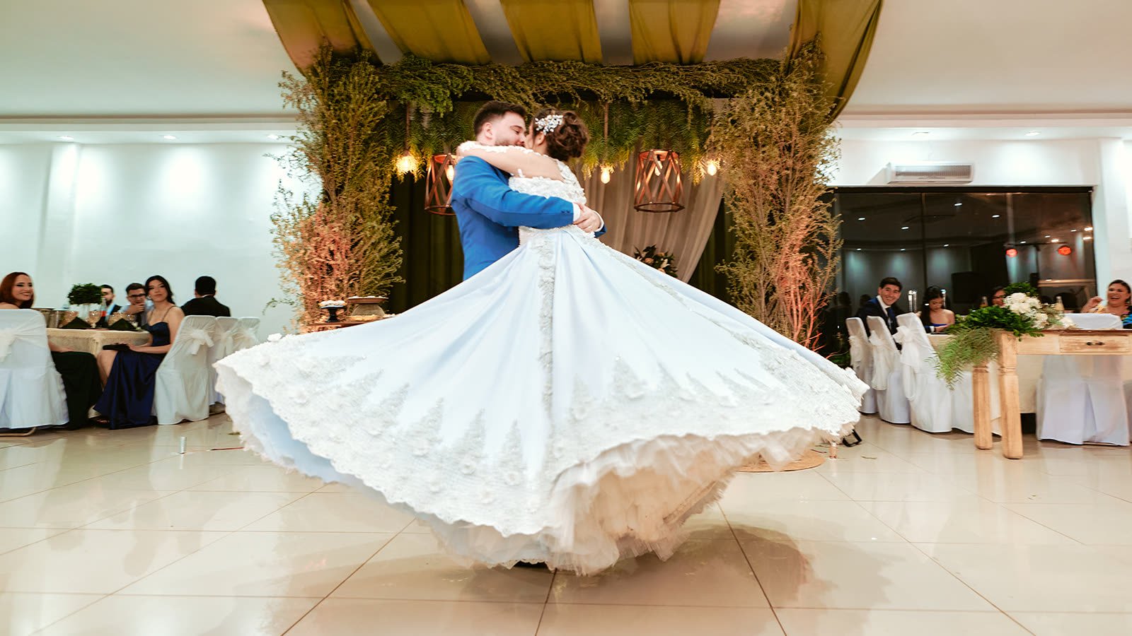 Novios girando en la pista de baile con el vestido en movimiento