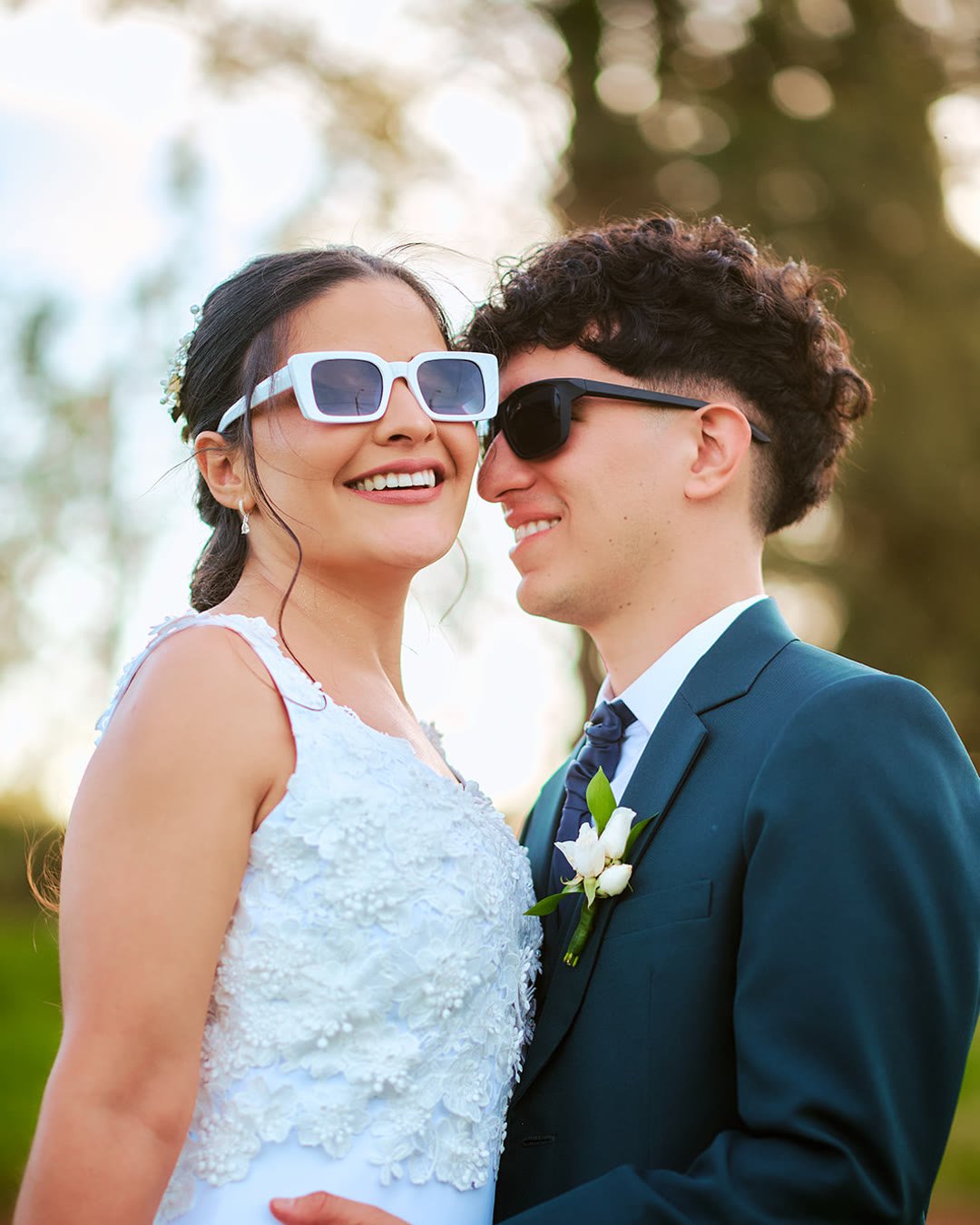 Novios sonriendo con anteojos de sol al aire libre