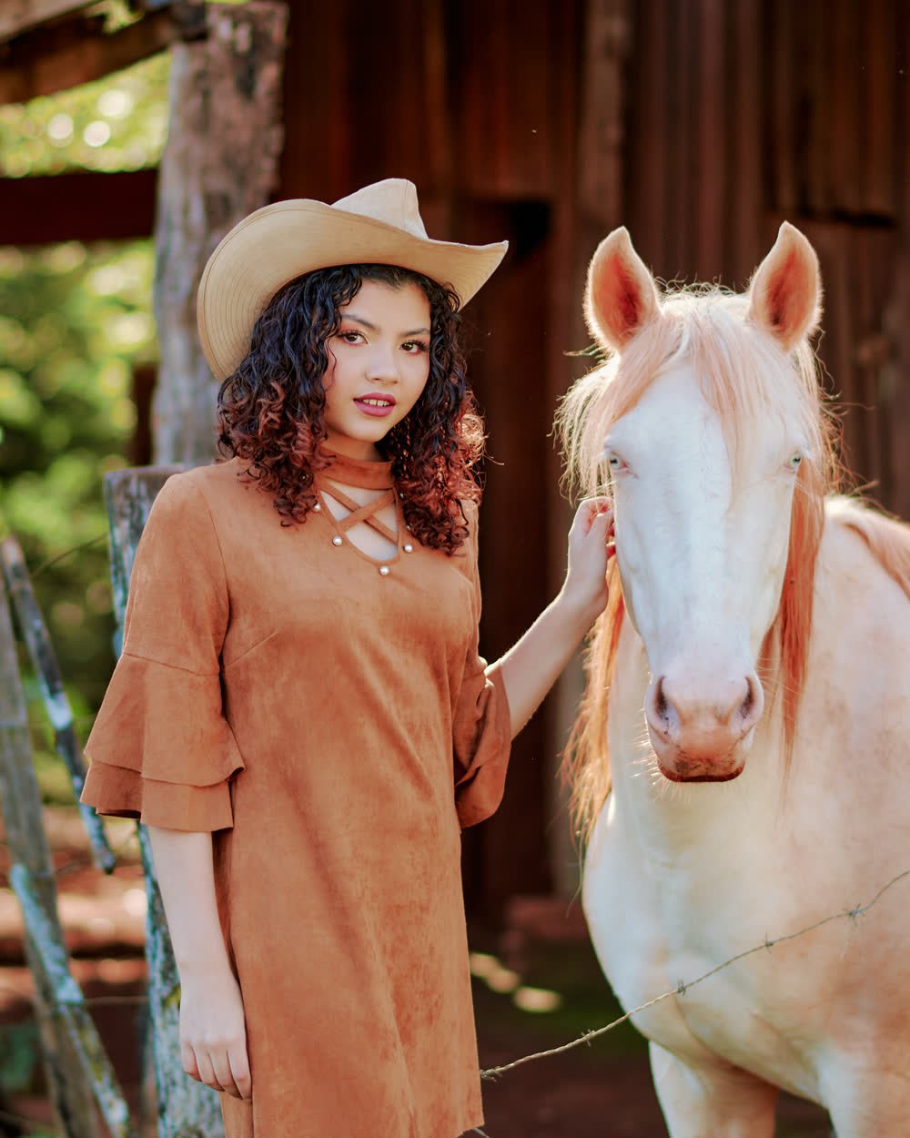 Sesión pre-xv al aire libre con sombrero vaquero junto a un caballo blanco