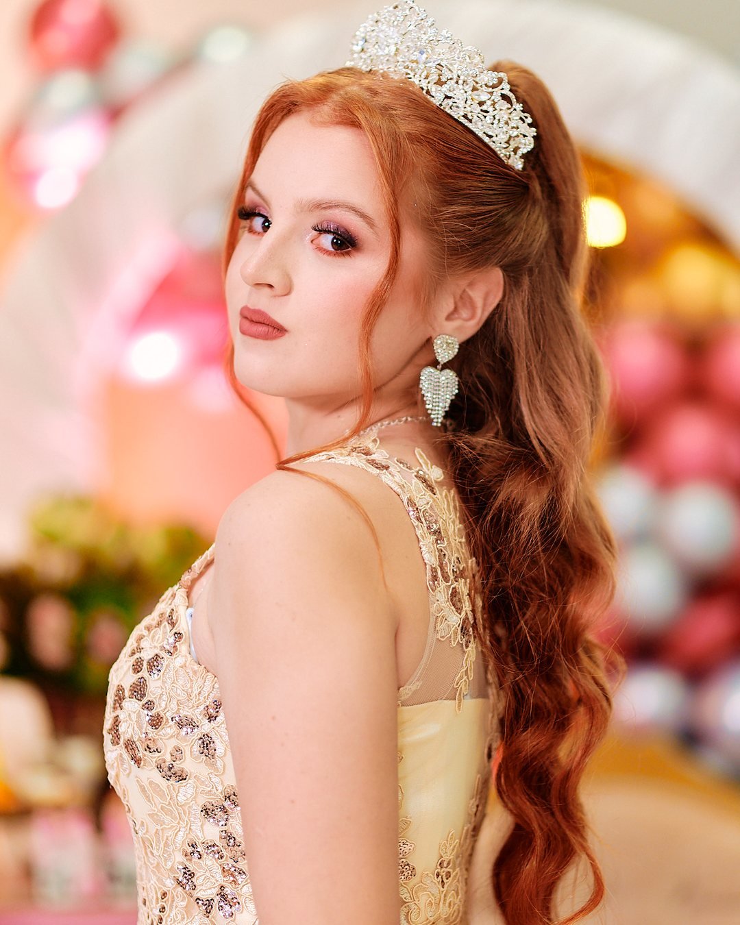 Quinceañera con vestido dorado y tiara, retrato de estudio