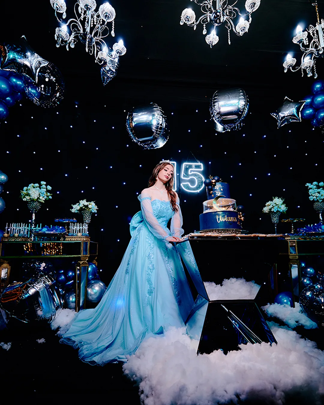 Quincea&ntilde;era junto a su torta en una fiesta de XV con decoraci&oacute;n azul en Encarnaci&oacute;n
